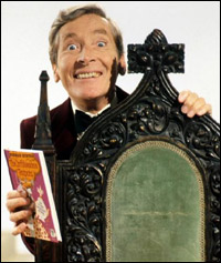 The late, great Kenneth Williams holding a book aloft