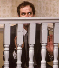 A man hiding behind a banister